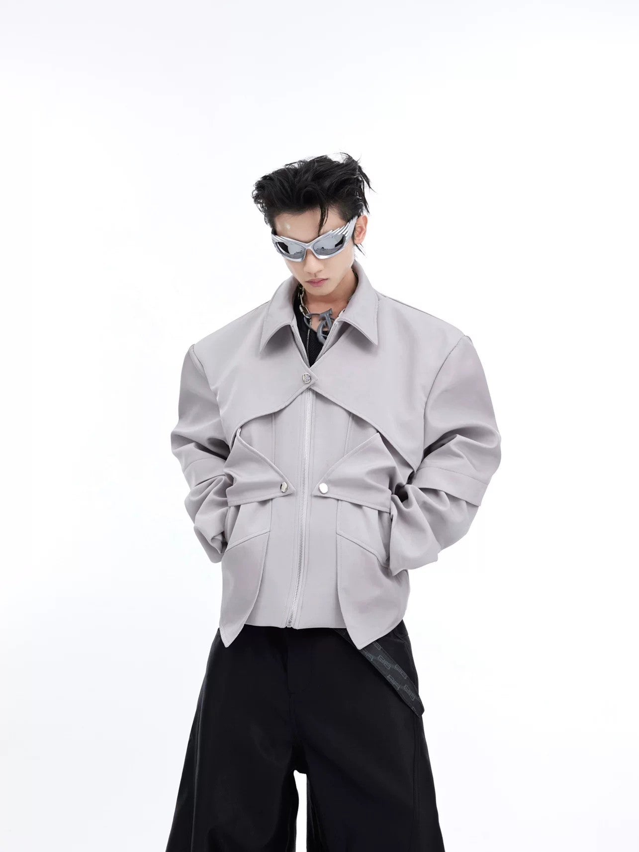 Close-up of the deconstructed patchwork and zipper detail on a metallic jacket