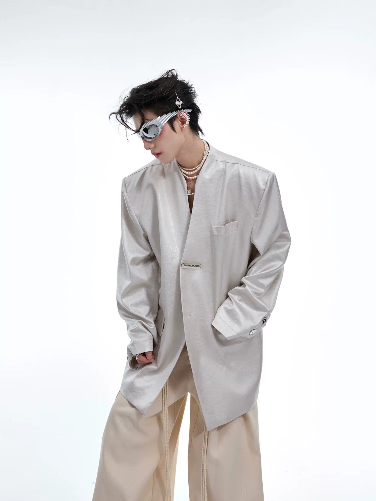 Model wearing black metallic collarless blazer in a street setting