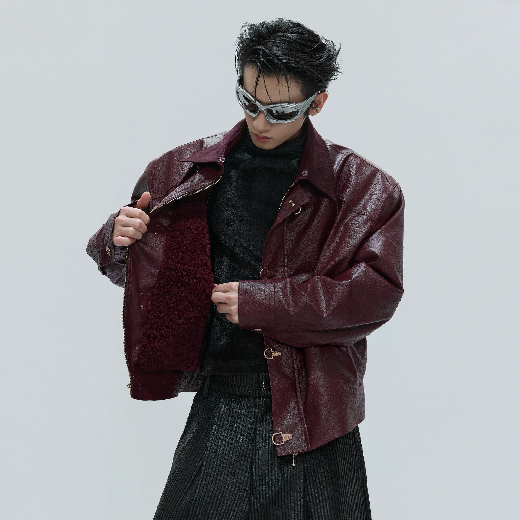 Bold red ostrich leather jacket featuring unique metal buckle closures.