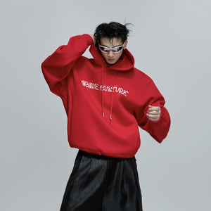 Model wearing red oversized heavyweight hoodie in urban street setting