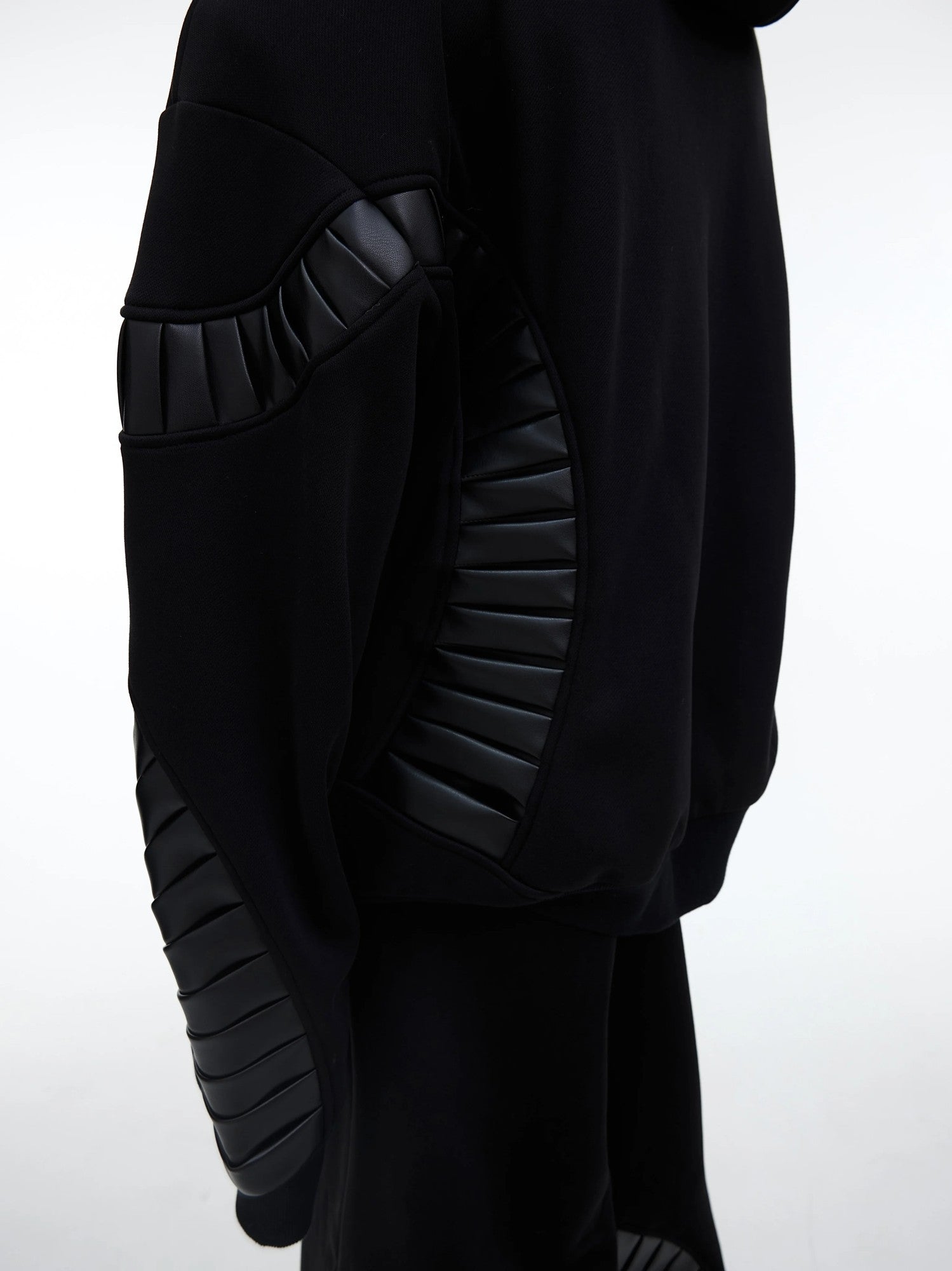 Side view of baggy black joggers with side seam pockets and patchwork