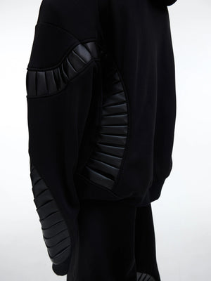 Side view of baggy black joggers with side seam pockets and patchwork