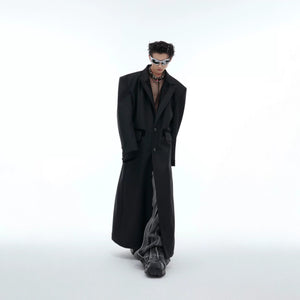 Front view of an oversized black long coat with PU leather splicing and padded shoulders.