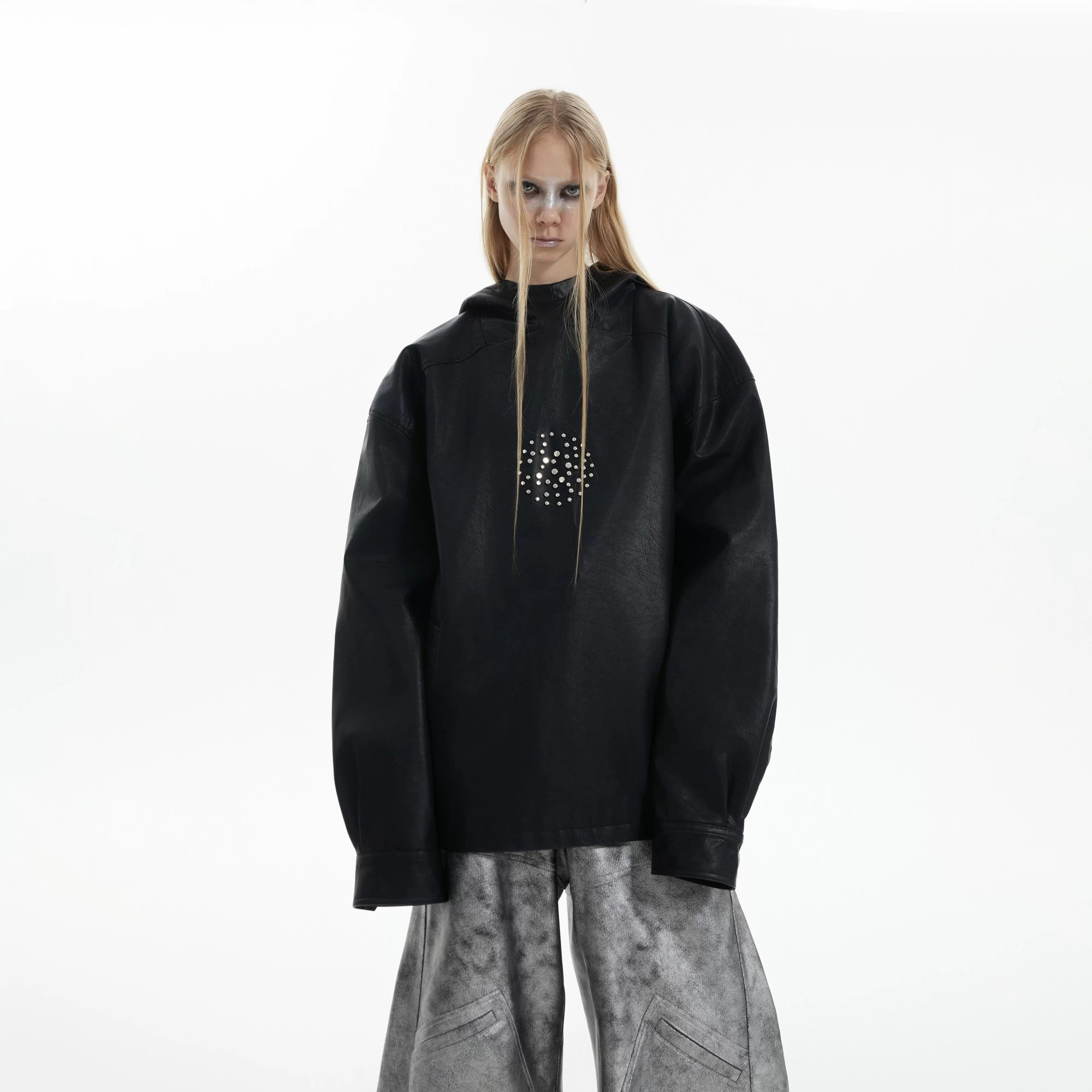 Close-up of metal rivet details on a black leather hoodie sleeve