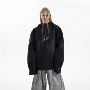 Close-up of metal rivet details on a black leather hoodie sleeve