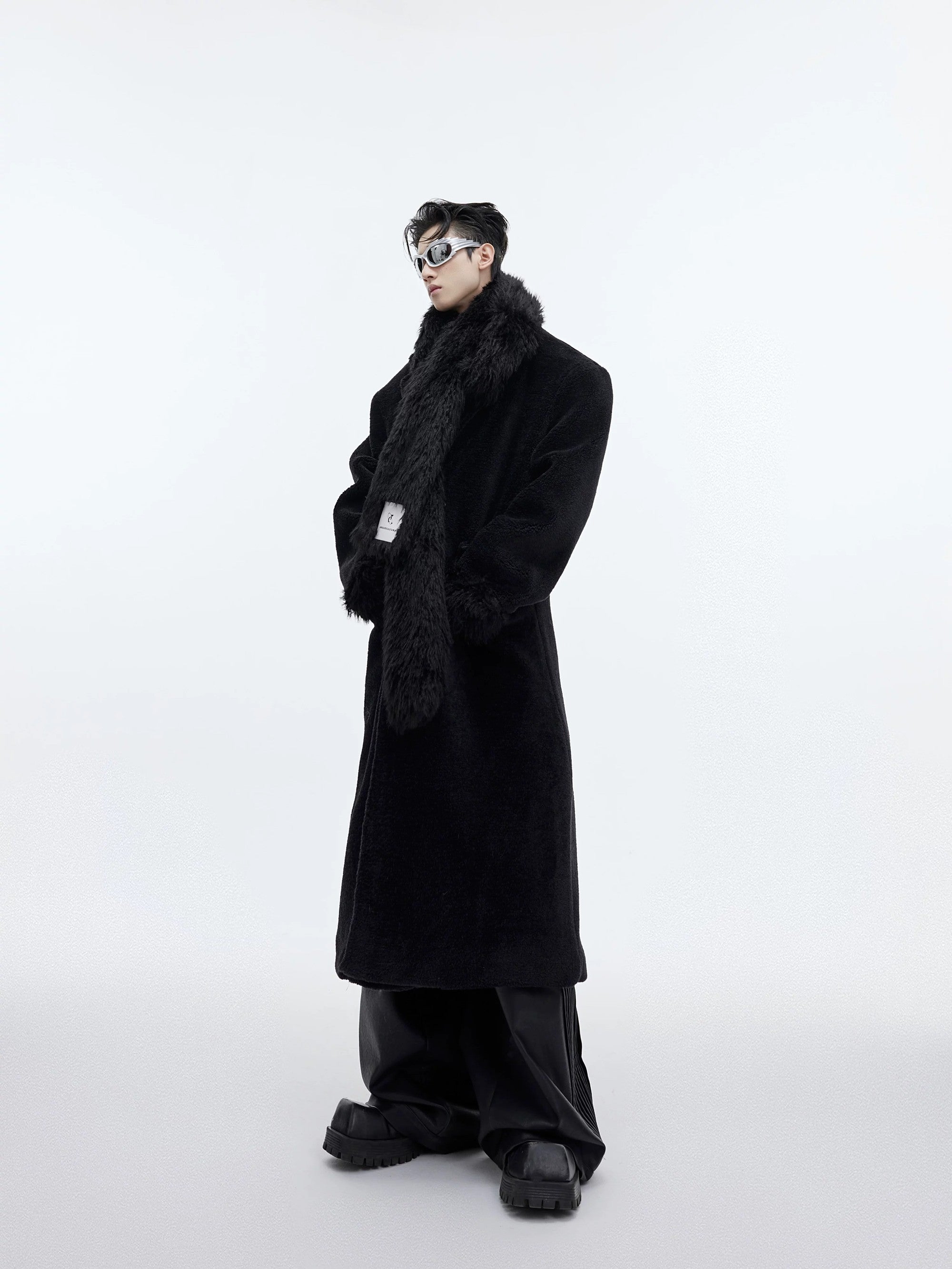 Man wearing black oversized wool coat with built-in scarf design