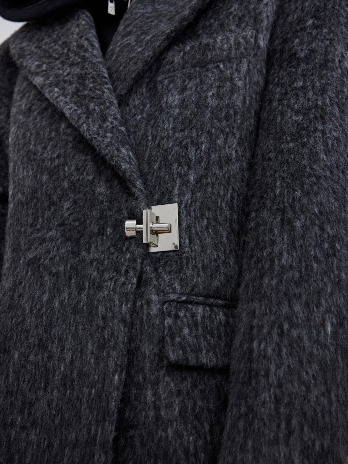 Close-up of the premium metal buckle closure on a wool coat