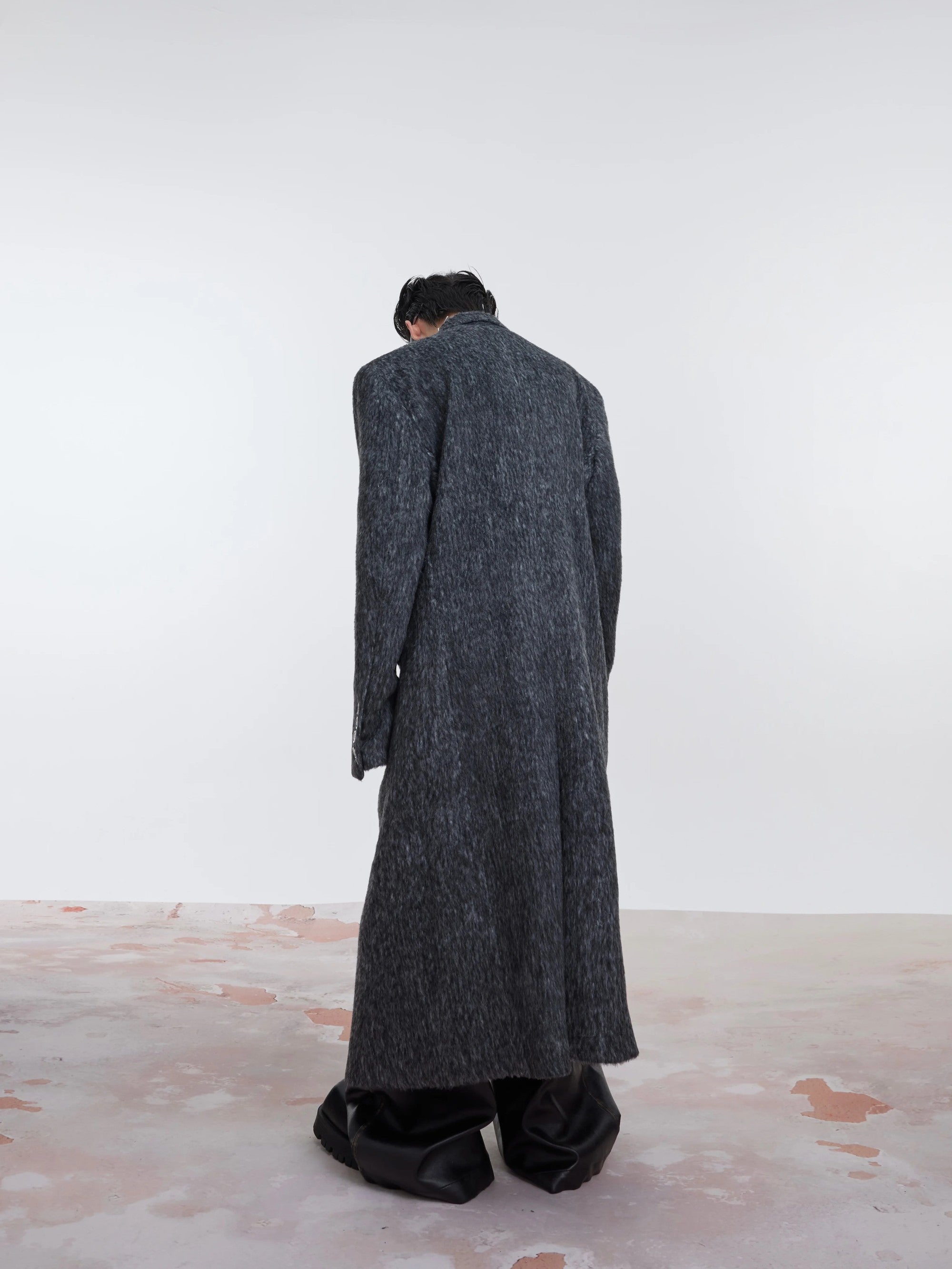 Back view of a loose fit solid color wool trench coat
