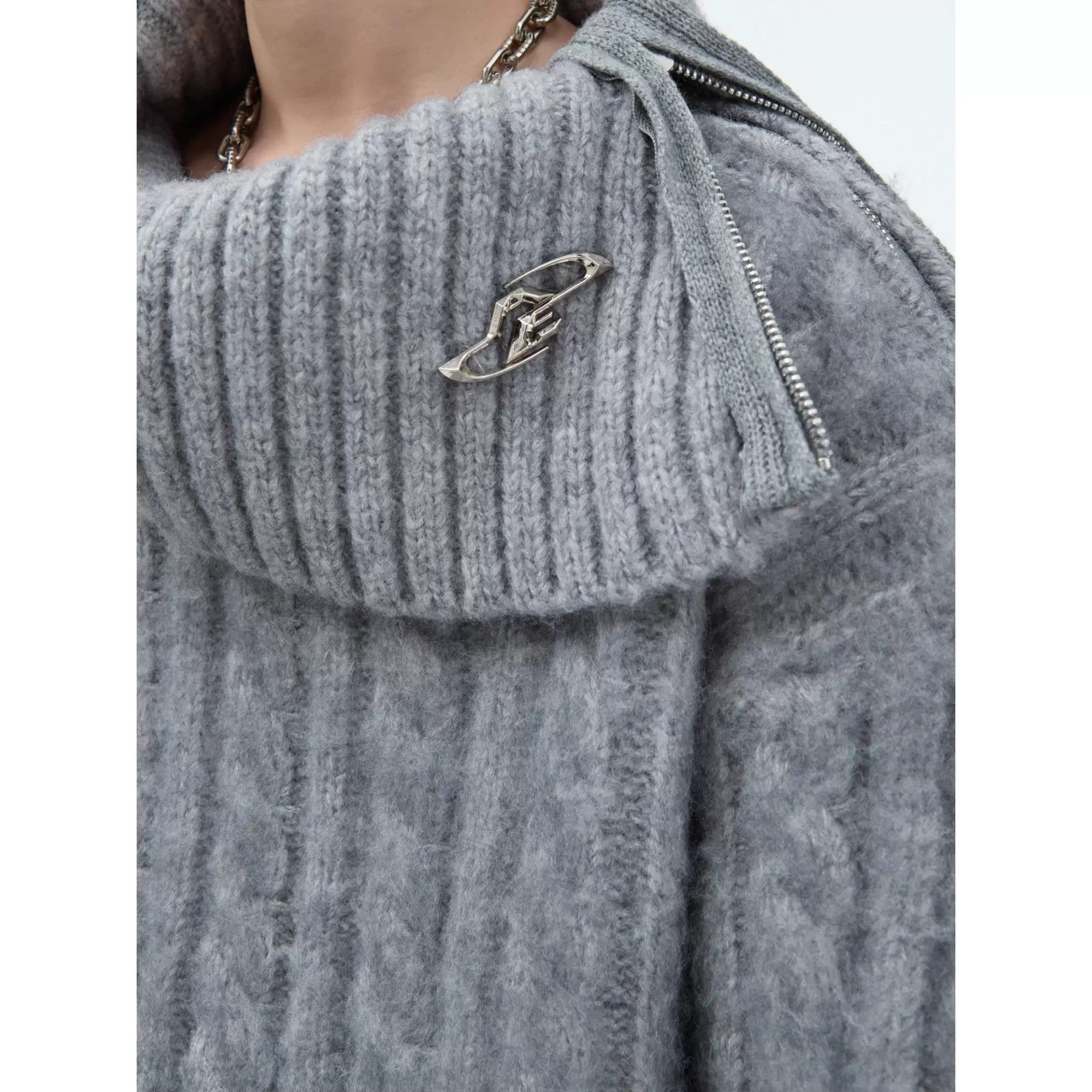 Detail shot of metal hardware on a split neck knit sweater