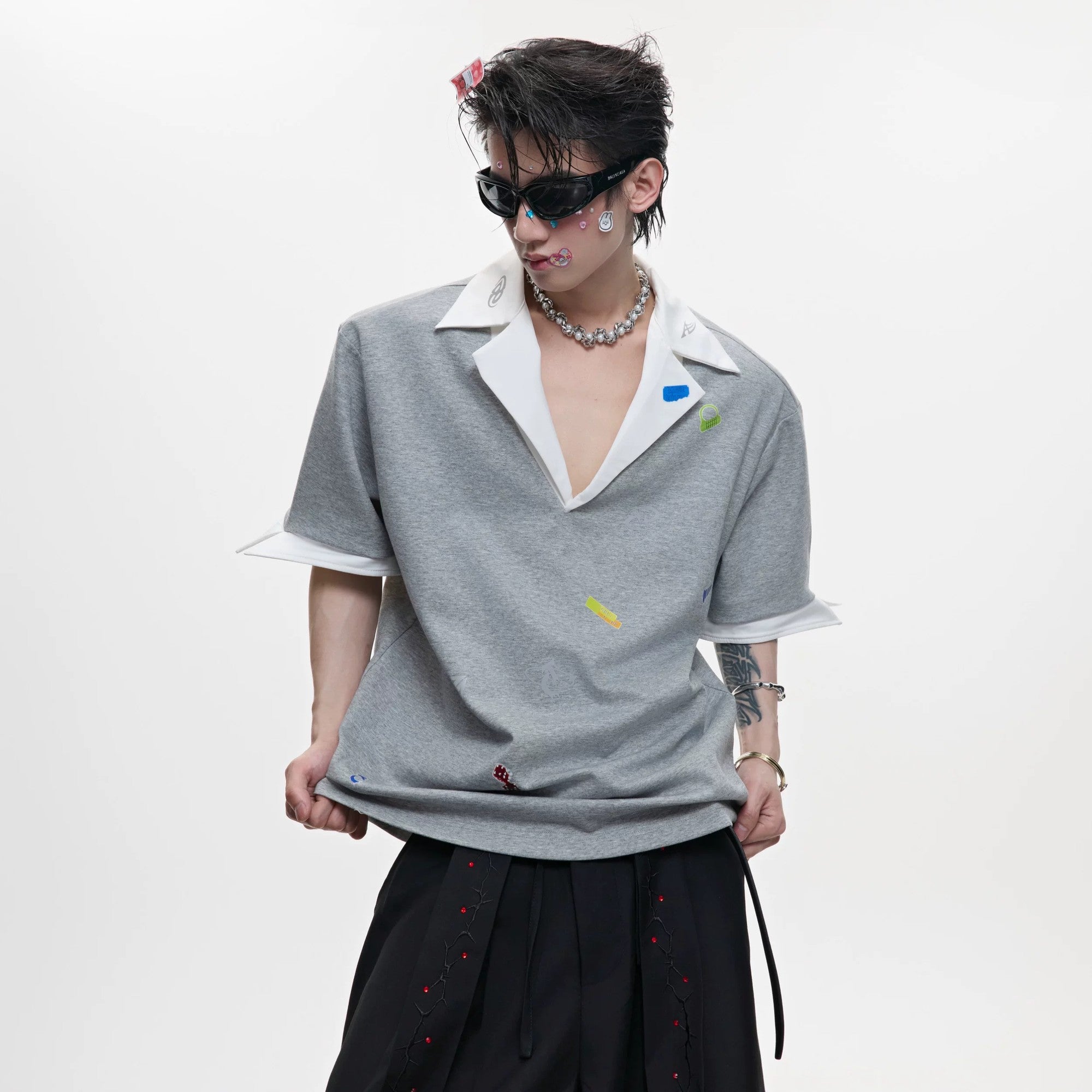 Front view of oversized V-neck polo with colorful sticker prints