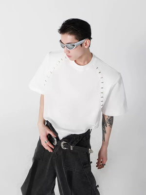 White oversized t-shirt with padded shoulders and metal bead details front view