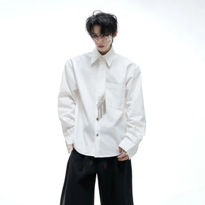 Close-up of shell buttons and chain detail on tie patchwork shirt