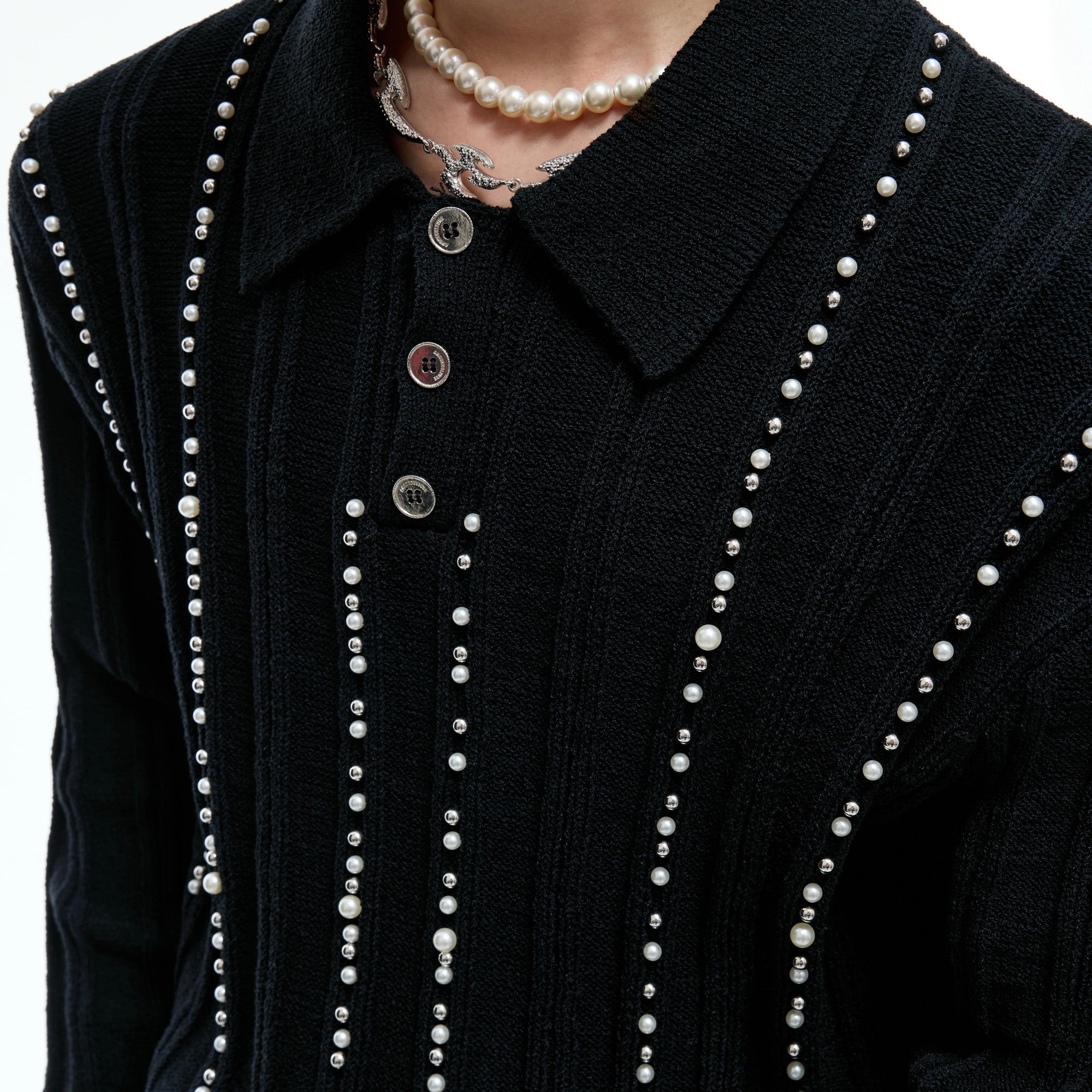 Close up of pearl and metal rivet embellishments on a polo collar