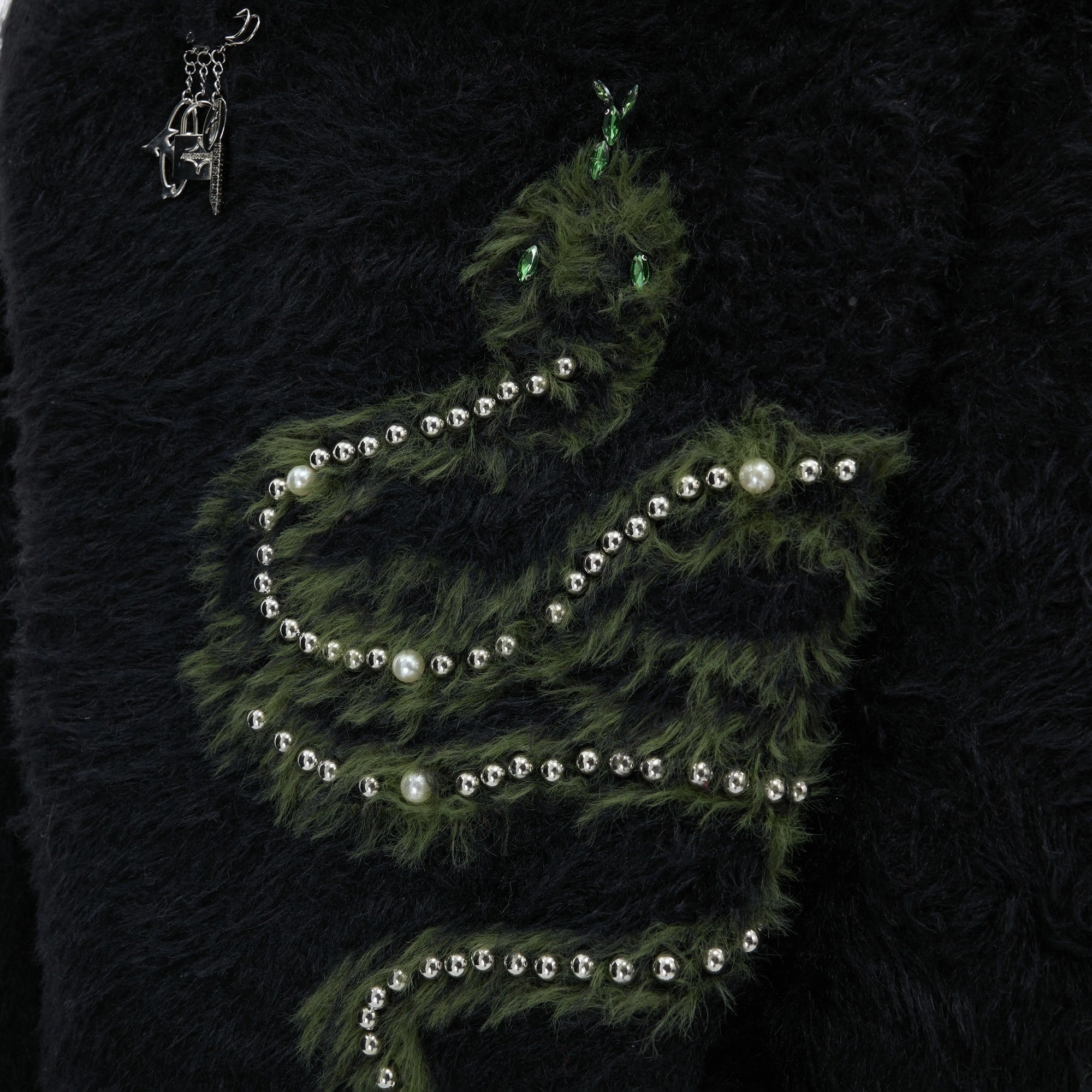 Close-up of hand-sewn pearls and gemstones on the snake pattern.