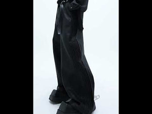 Video showing 360-degree view of textured leather pants with side pleats and relaxed fit