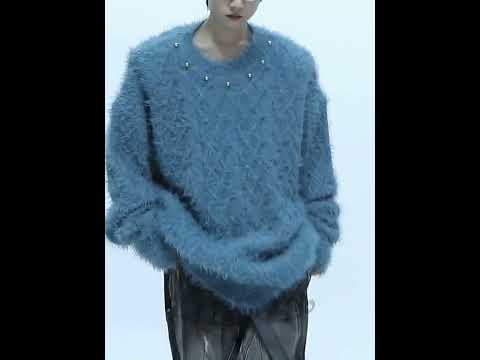 Video showcasing the oversized knit pullover from all angles, highlighting its metal buttons and premium fabric