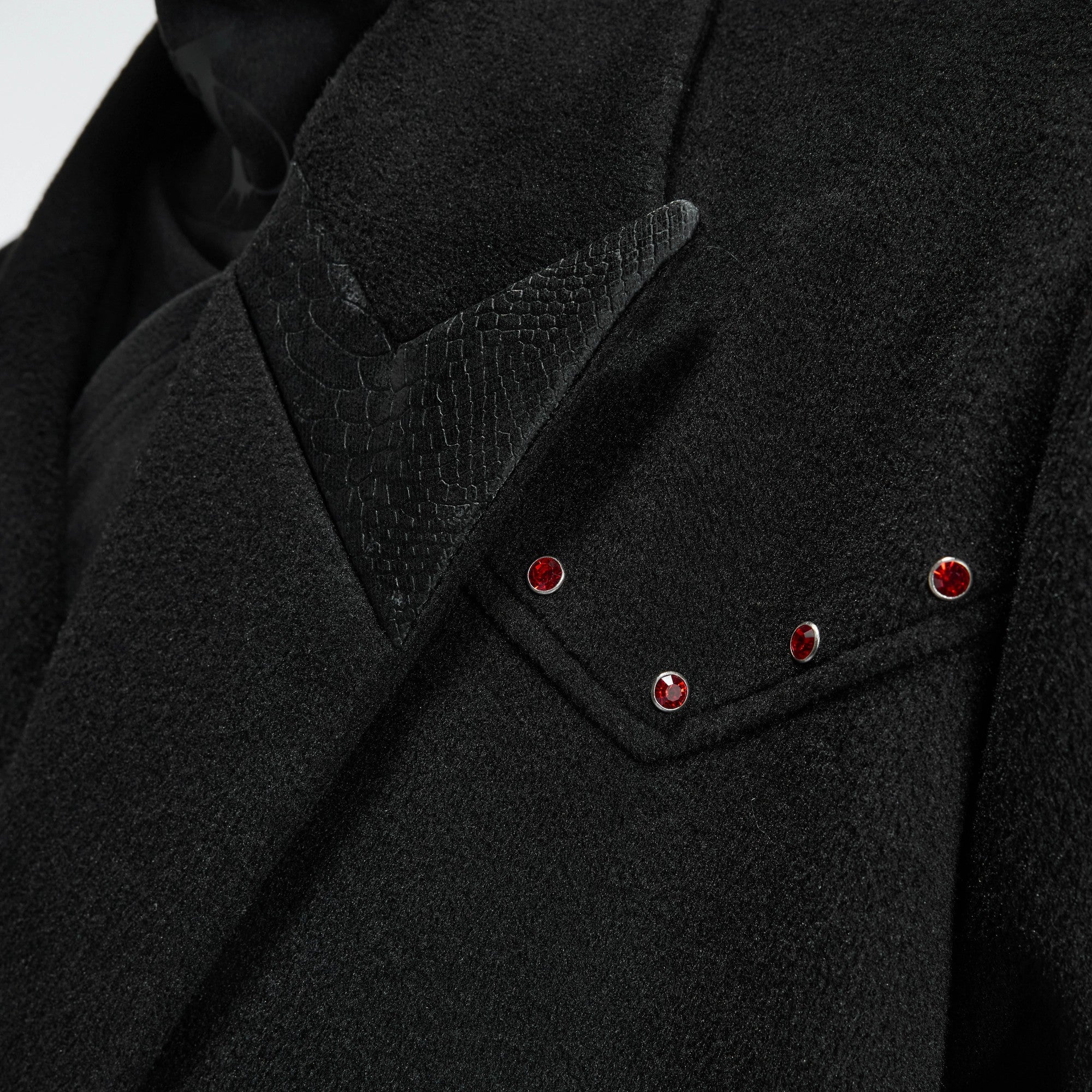 Close-up of the red diamond metal decoration on the wool jacket
