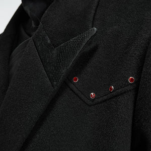 Close-up of the red diamond metal decoration on the wool jacket