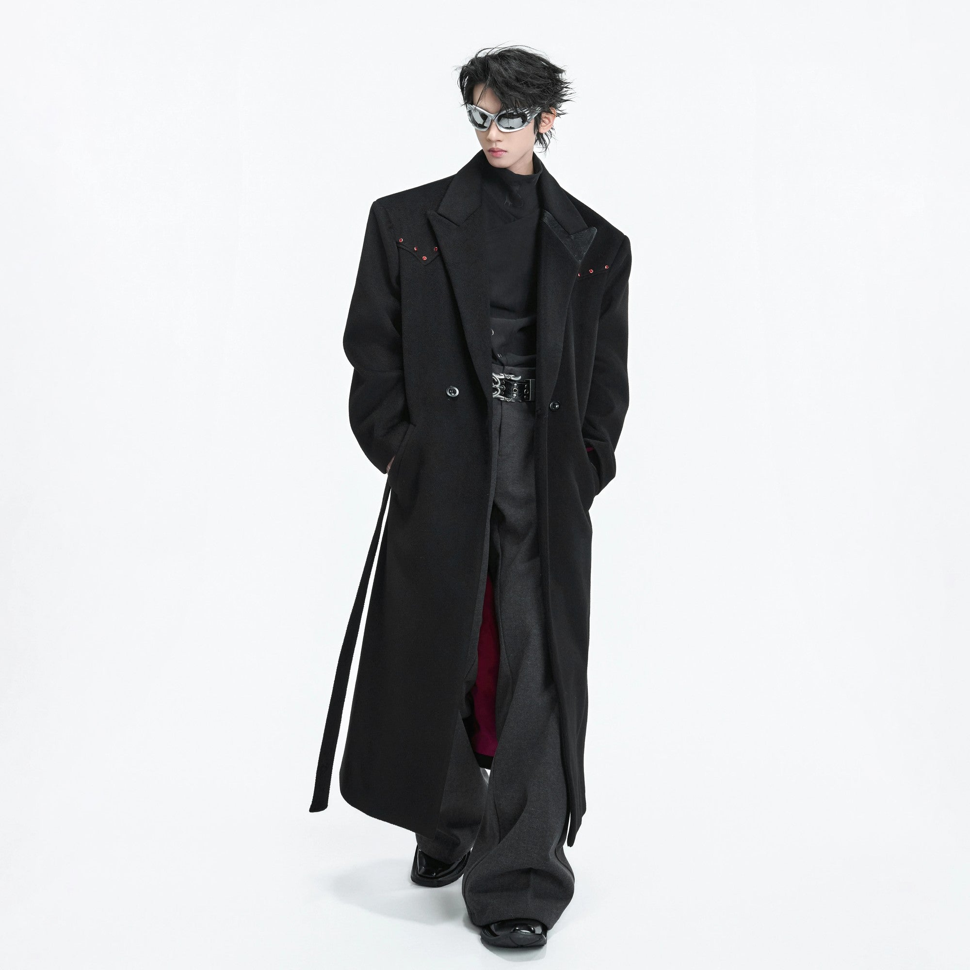 Street style shot of a model wearing the long double-breasted black coat