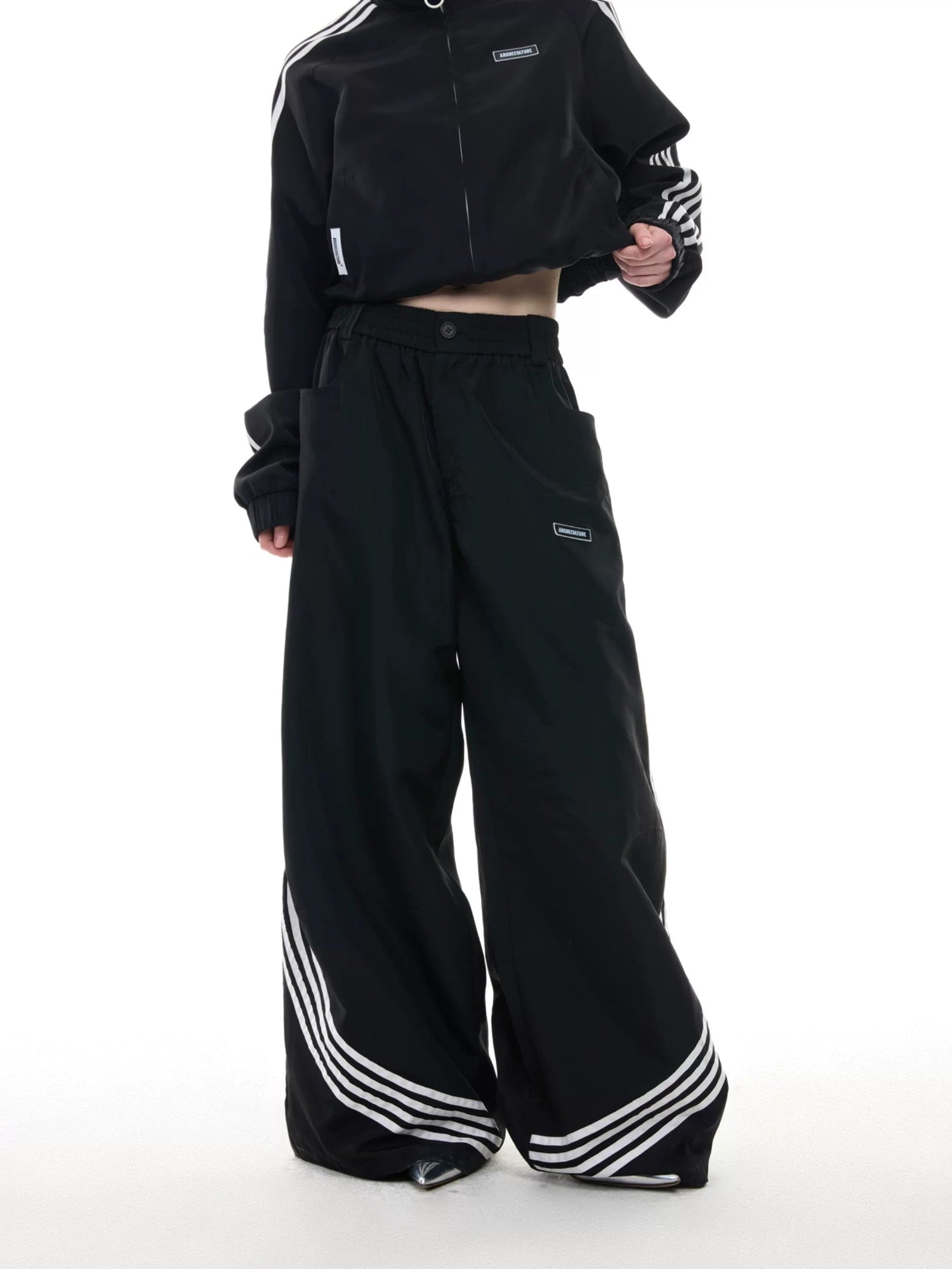 Side view of wide-leg baggy track pants with 4-stripe design