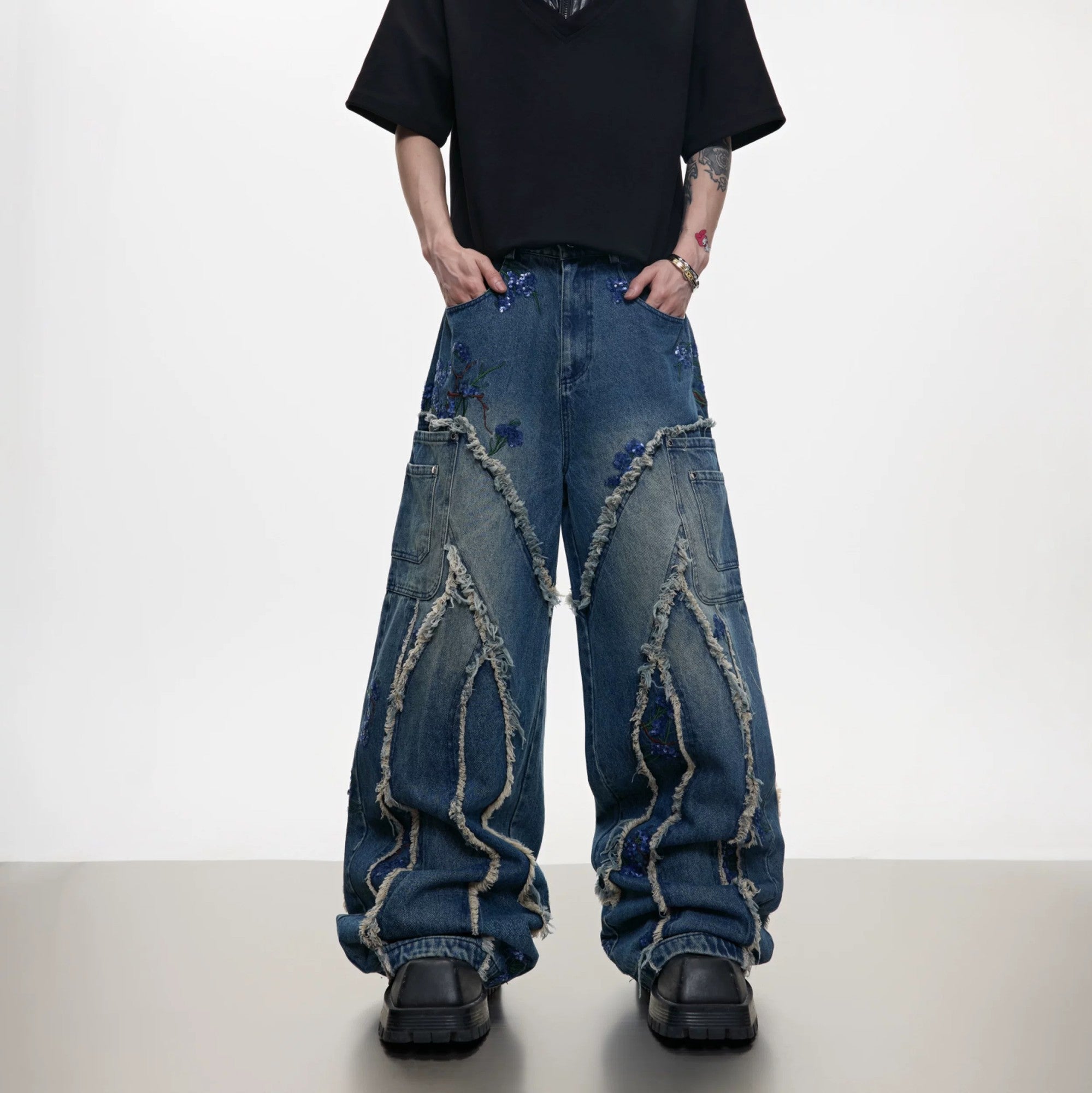 Front view of blue baggy jeans with sequin embroidery and distressed details.