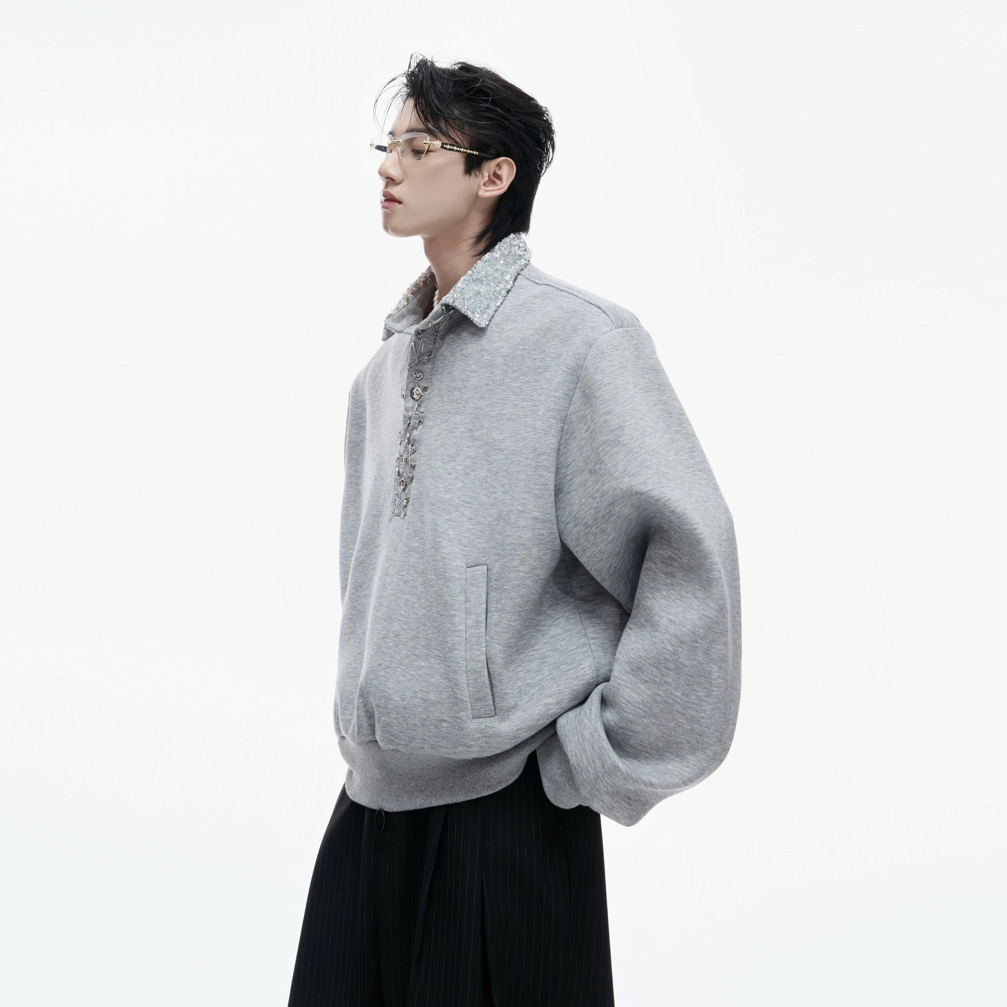 Black streetwear polo sweatshirt with sequin details and safety pin