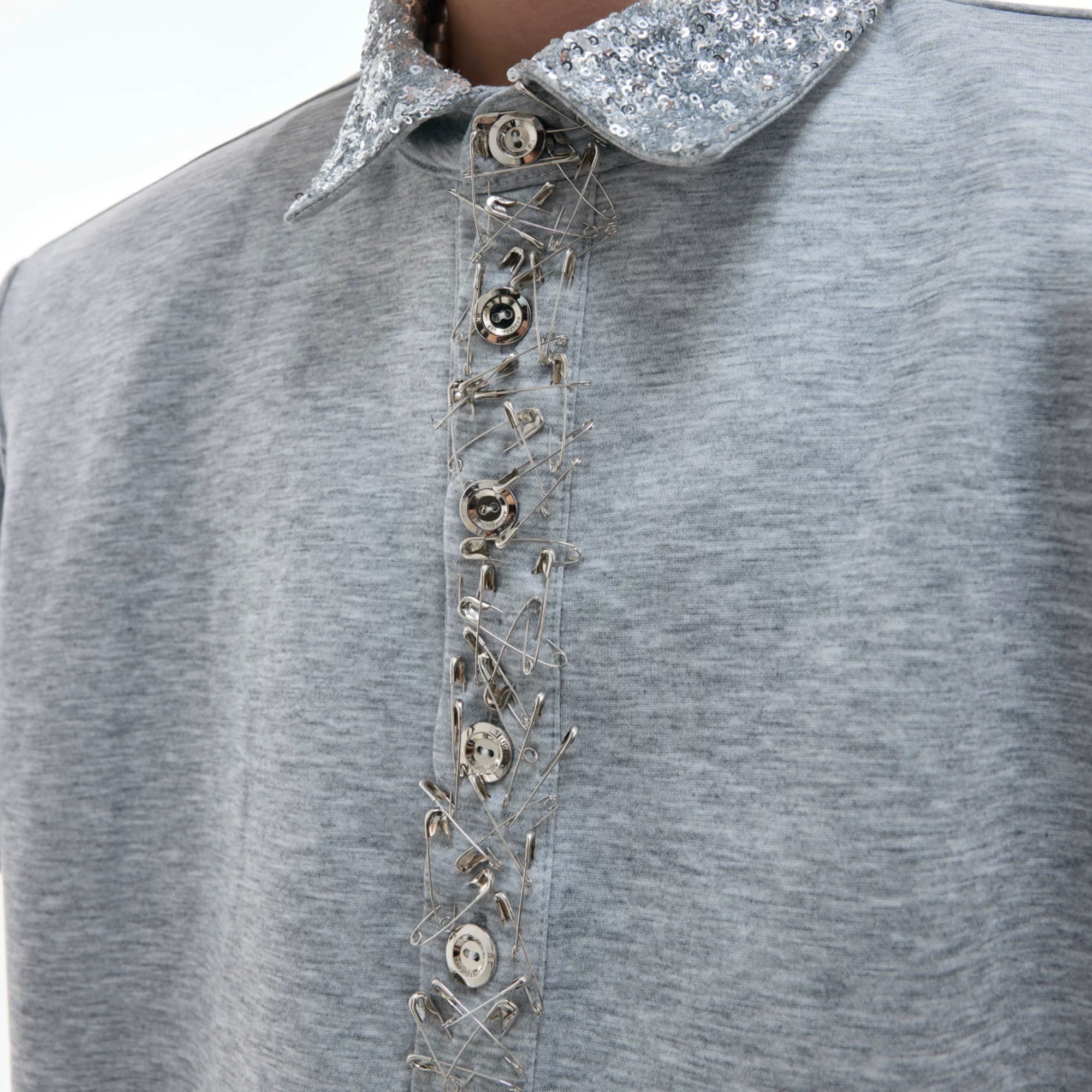 Oversized fit demonstration of the sequin polo with detachable shoulder pads.