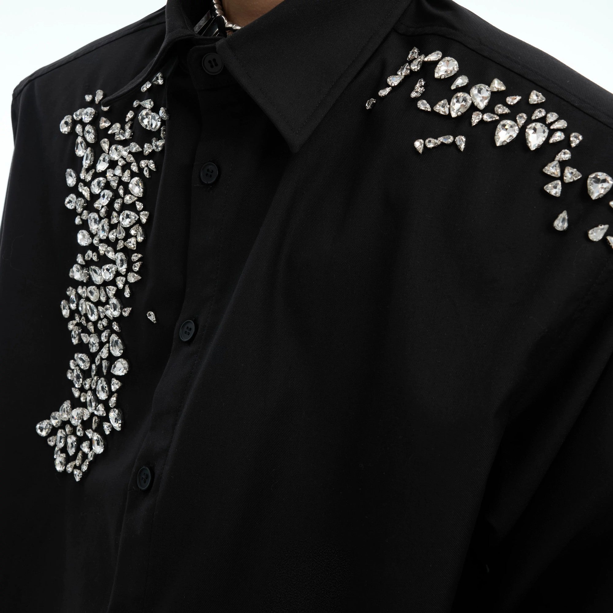 Model wearing a black oversized rhinestone shirt for a banquet scene.