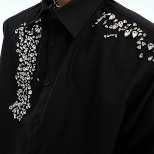 Model wearing a black oversized rhinestone shirt for a banquet scene.