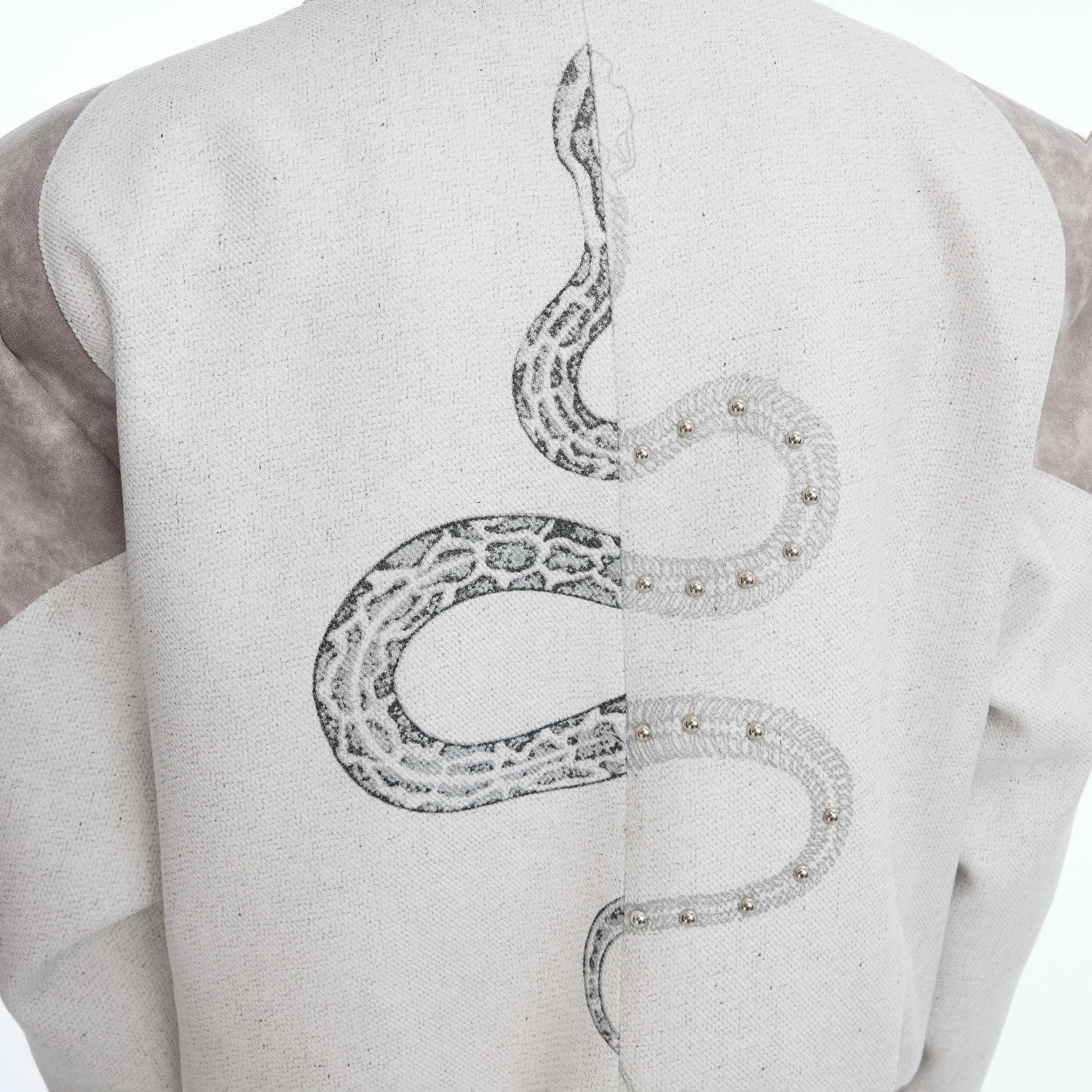 Back view of a cropped jacket with intricate serpent embroidery.