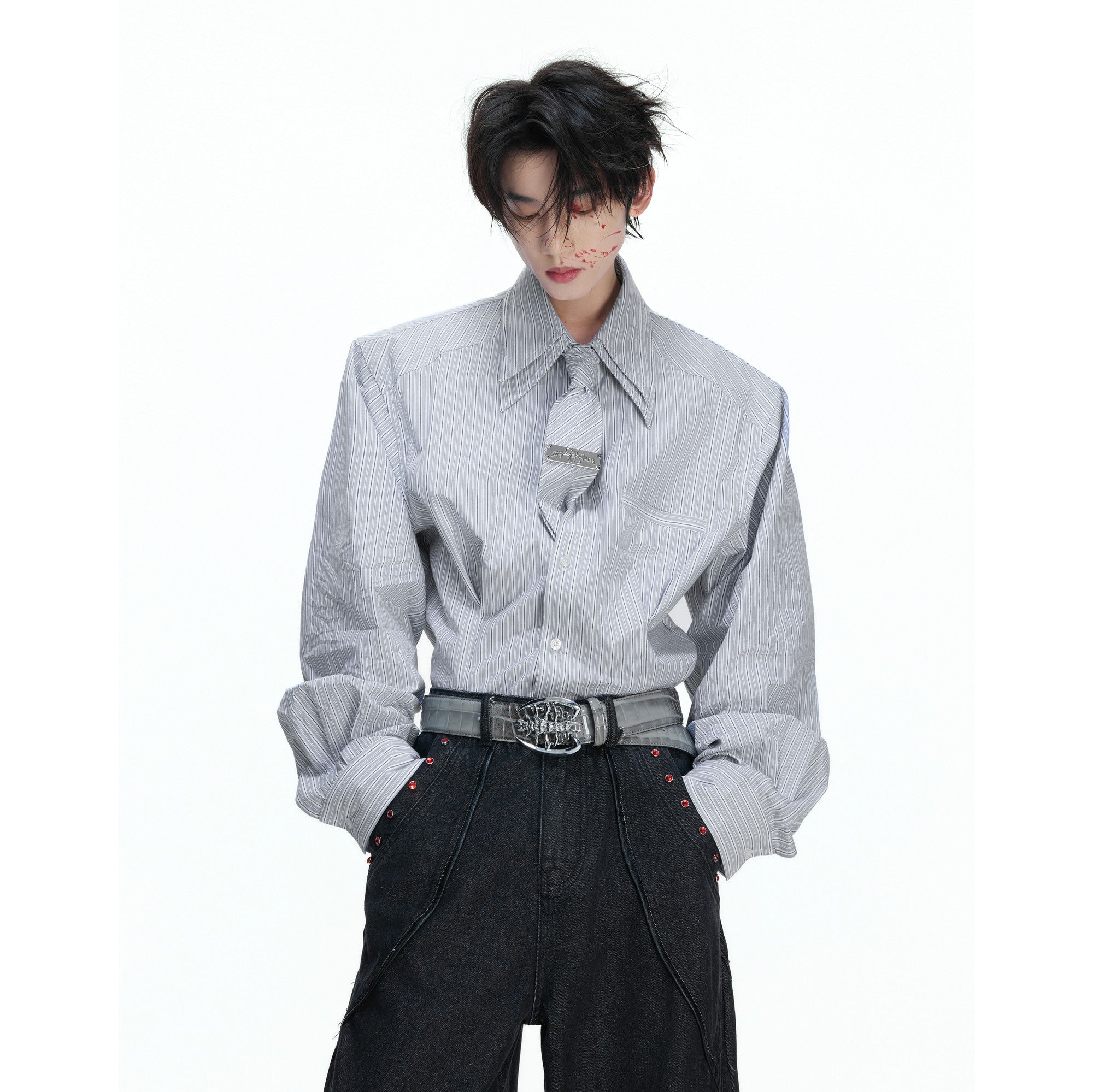 Close-up of a detachable striped tie with a metallic brand logo plate.