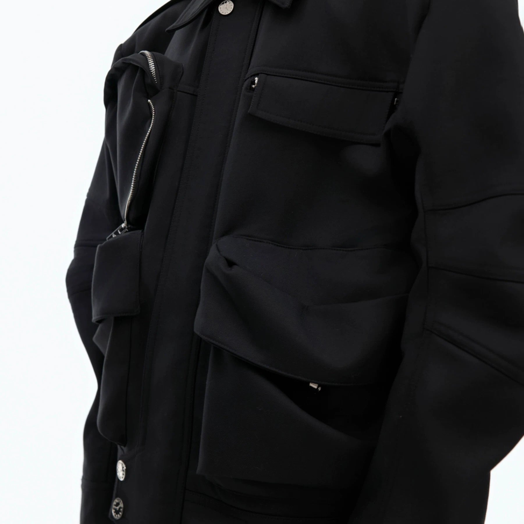 Close up of pleated curved sleeve design on a techwear jacket