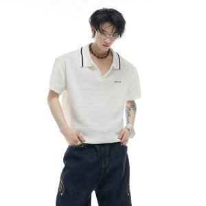 Model wearing blue oversized knit polo in a street setting