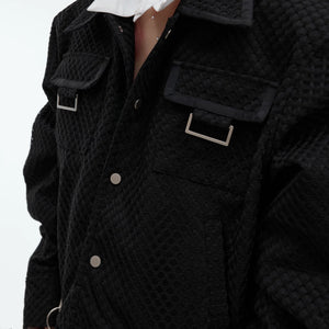 Model wearing a boxy deconstructed jacket in a street setting