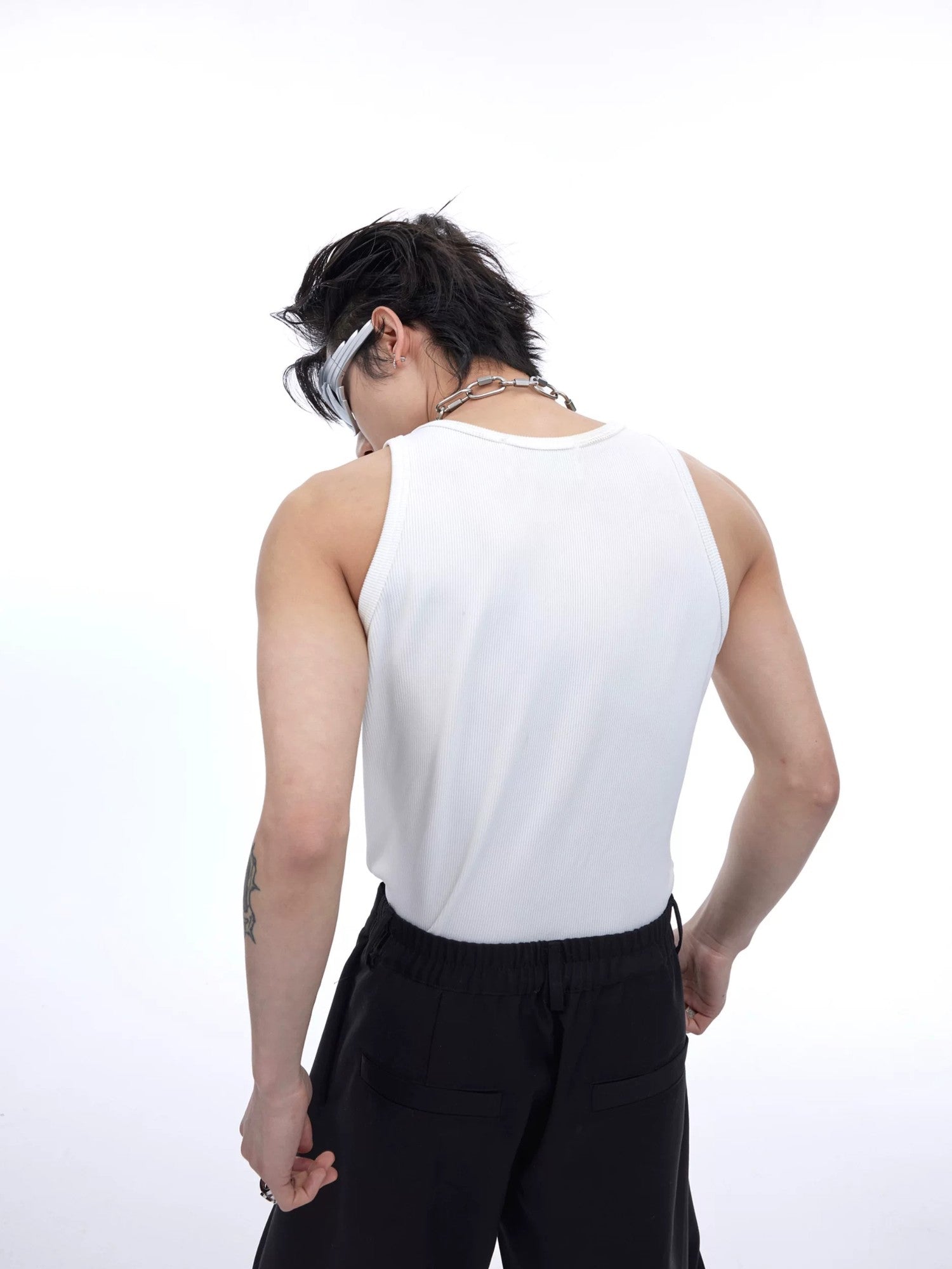 Model wearing a slim fit white racerback tank in a street setting