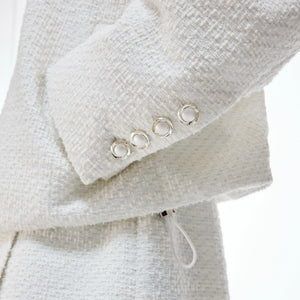 Model wearing black tweed streetwear set with wide-leg pants in urban setting