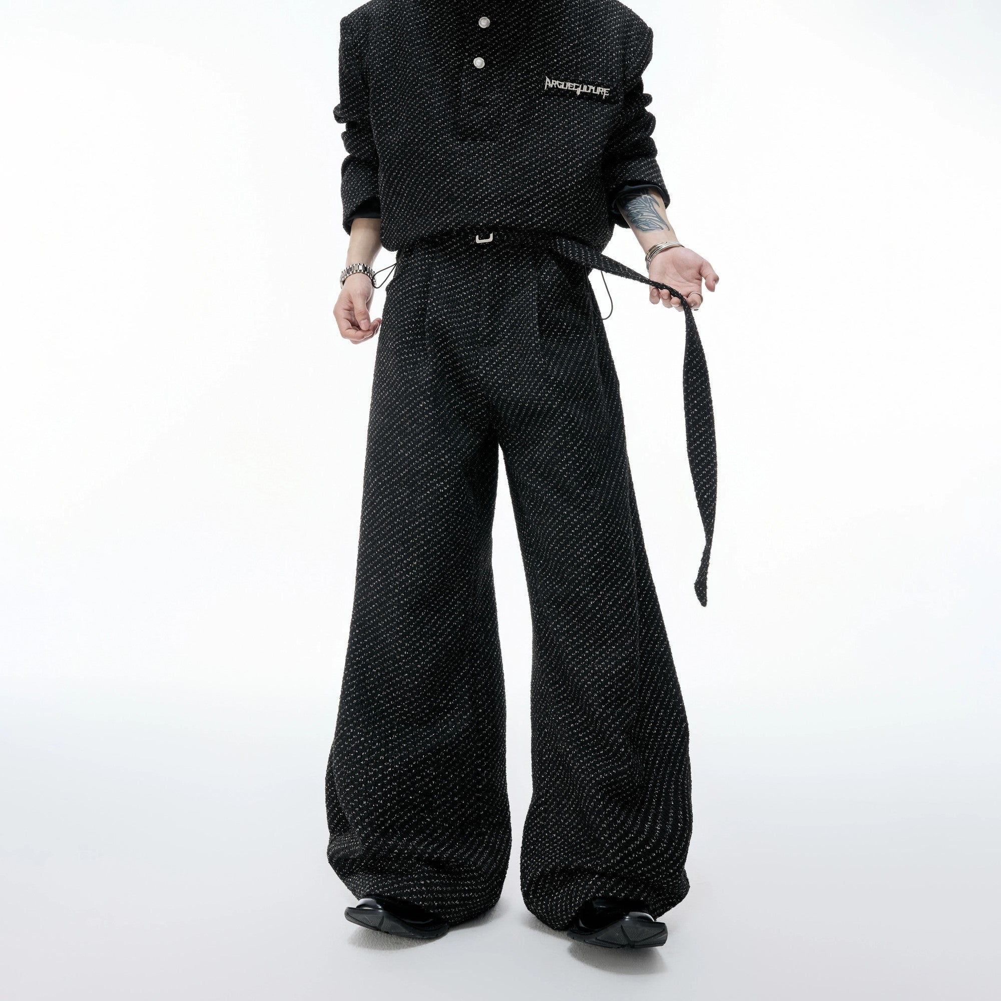 Detailed view of the curved leg design on tweed textured trousers