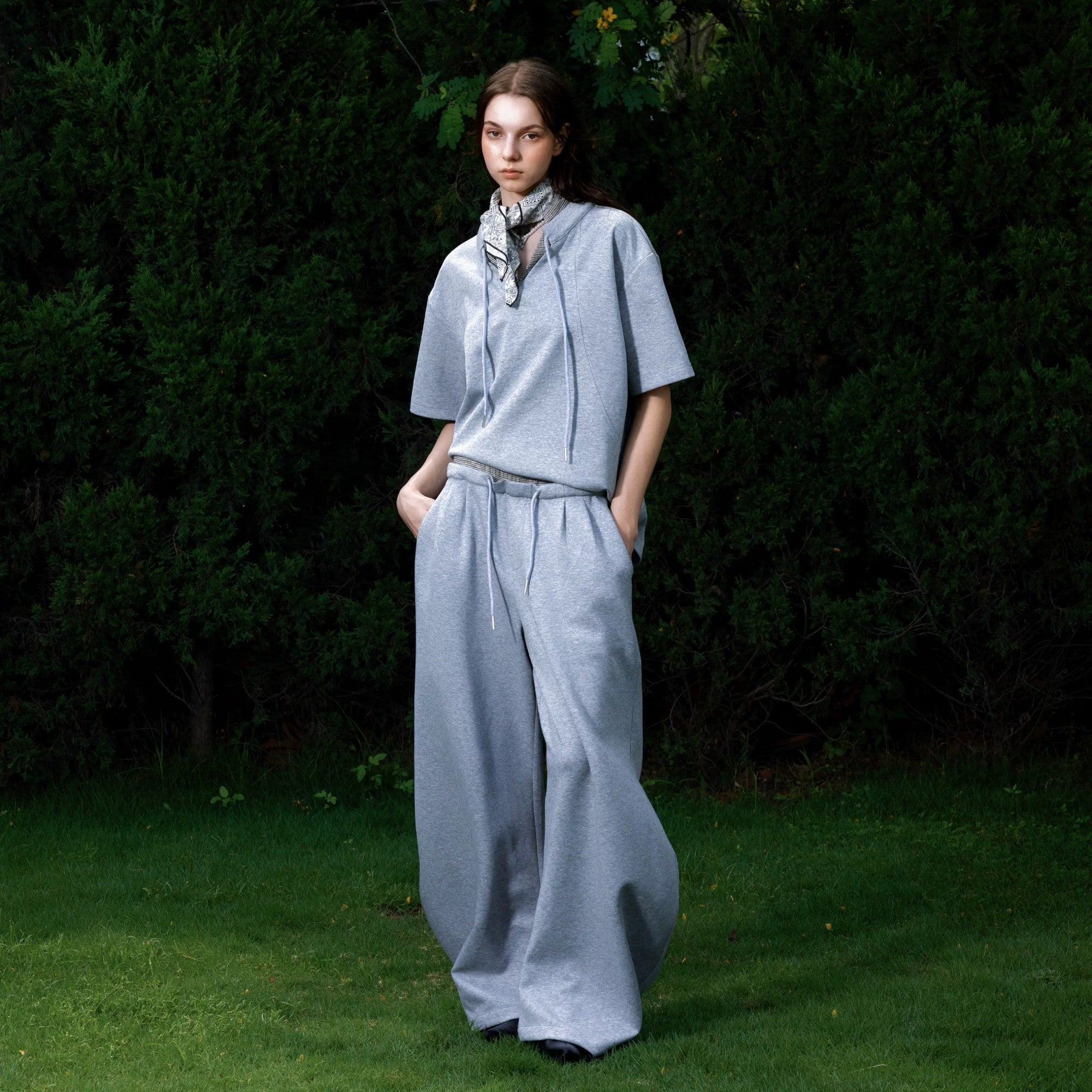 Close up of the double waistband and curved leg design on gray sweatpants