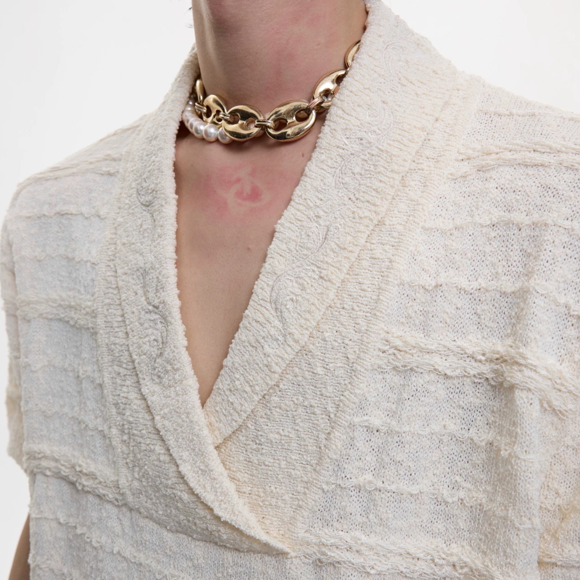 Close up of high density embroidery on V-neck knit summer sweater