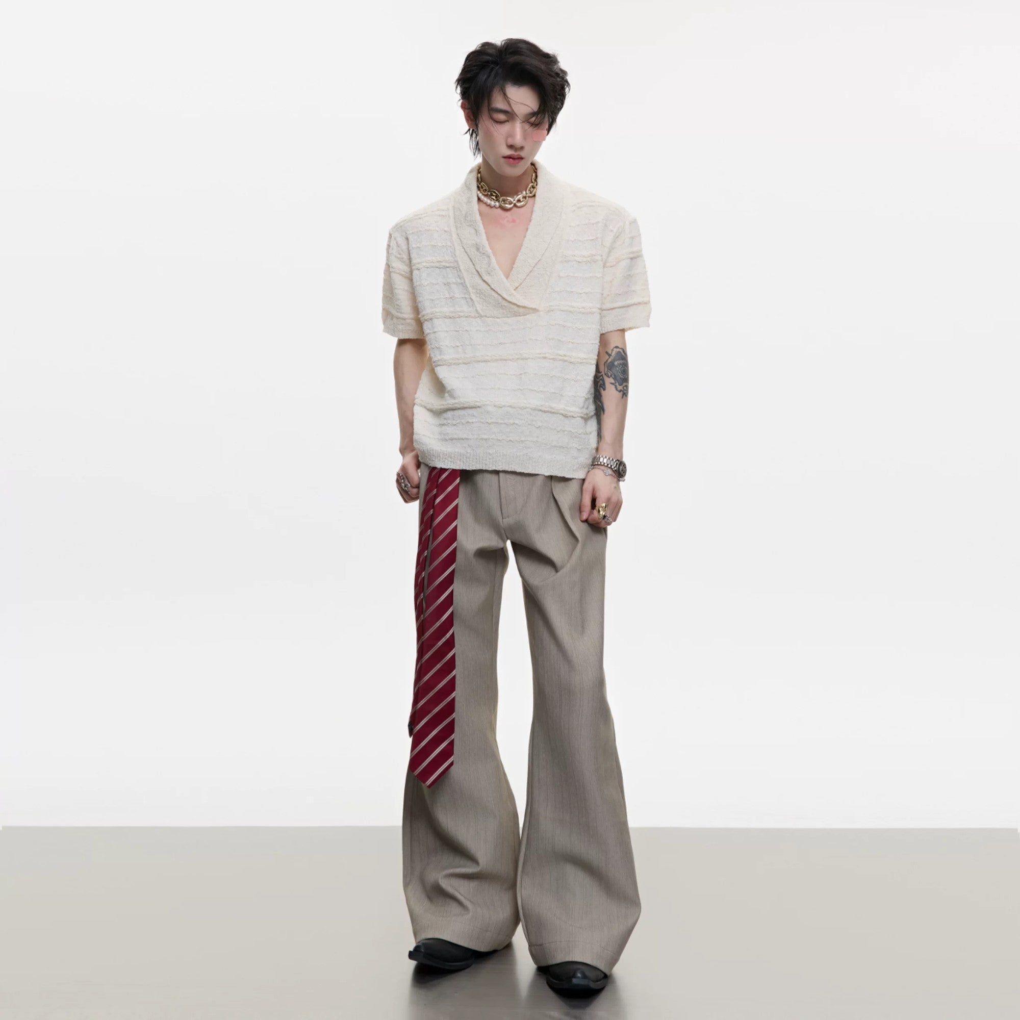 Model wearing loose fit V-neck knit tee in a streetwear setting