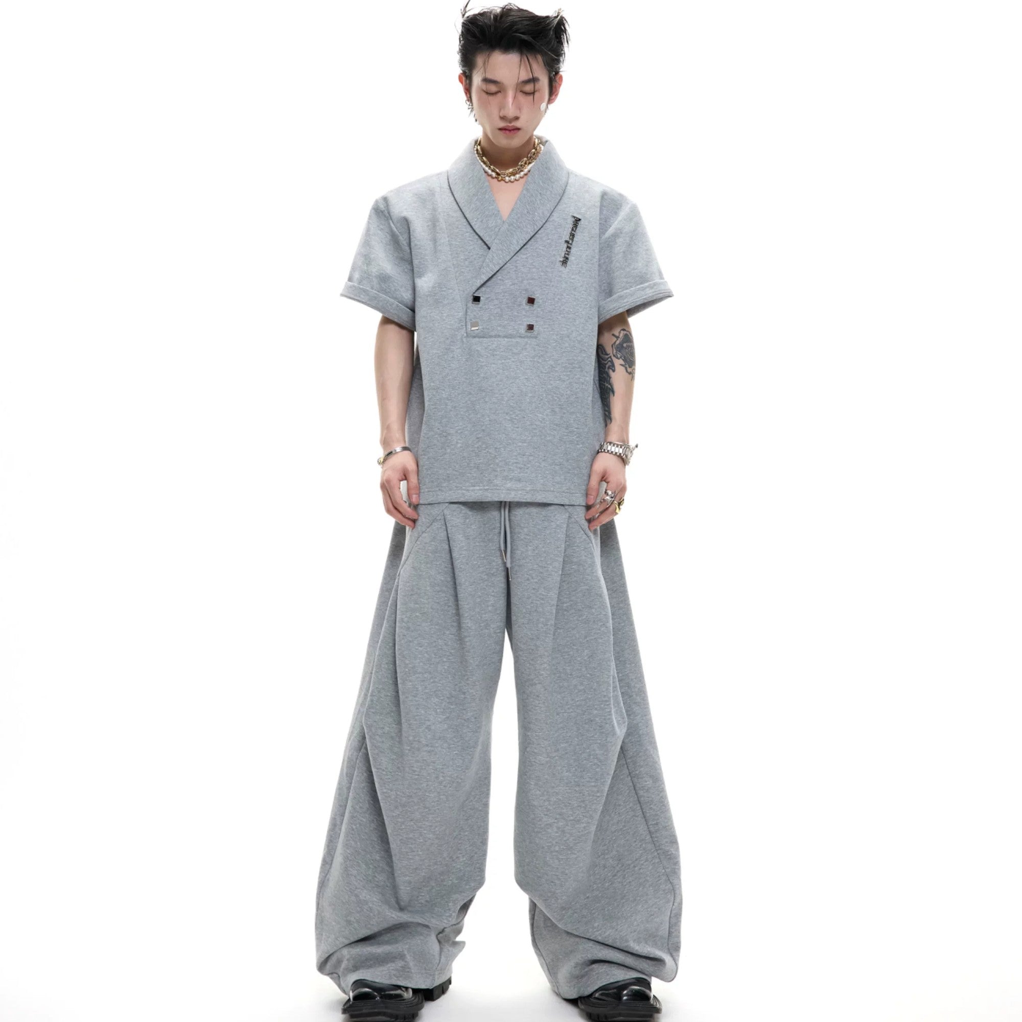 Black V-neck padded shoulder T-shirt and shorts set with metal accents