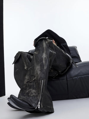 Street style shot of a model wearing deconstructed flared leather pants.