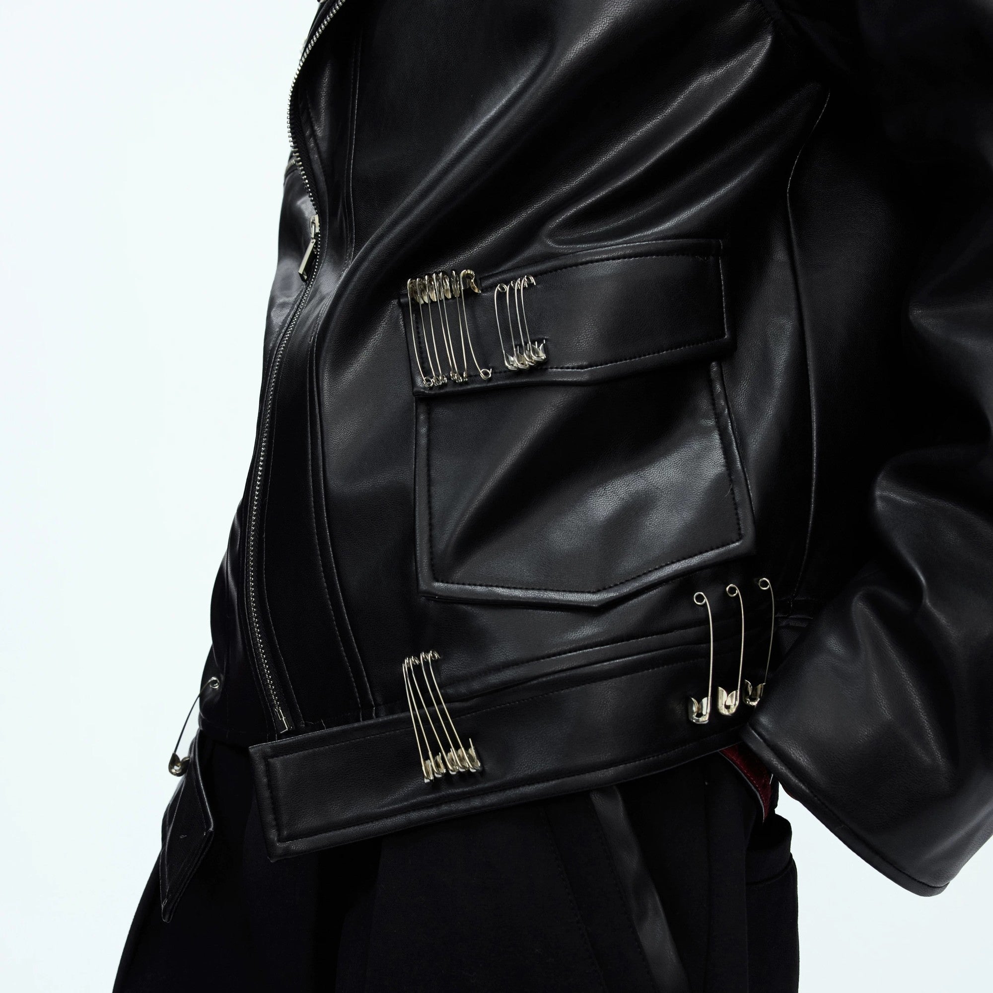 Close up of metal pin accents and deconstructed zipper details