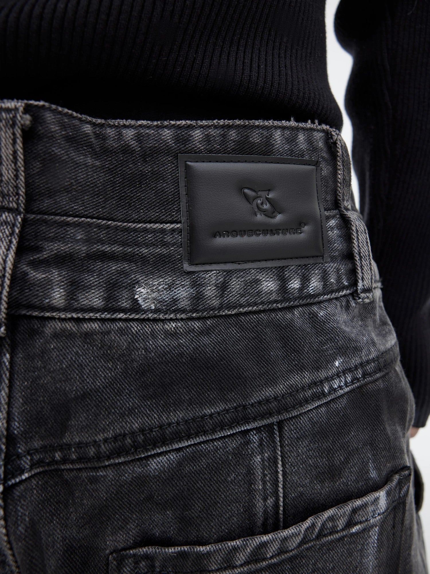 Streetwear model wearing wide-leg distressed jeans and sneakers