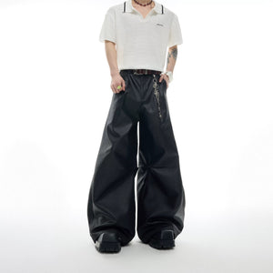 Front view of black metallic waxed wide-leg streetwear trousers