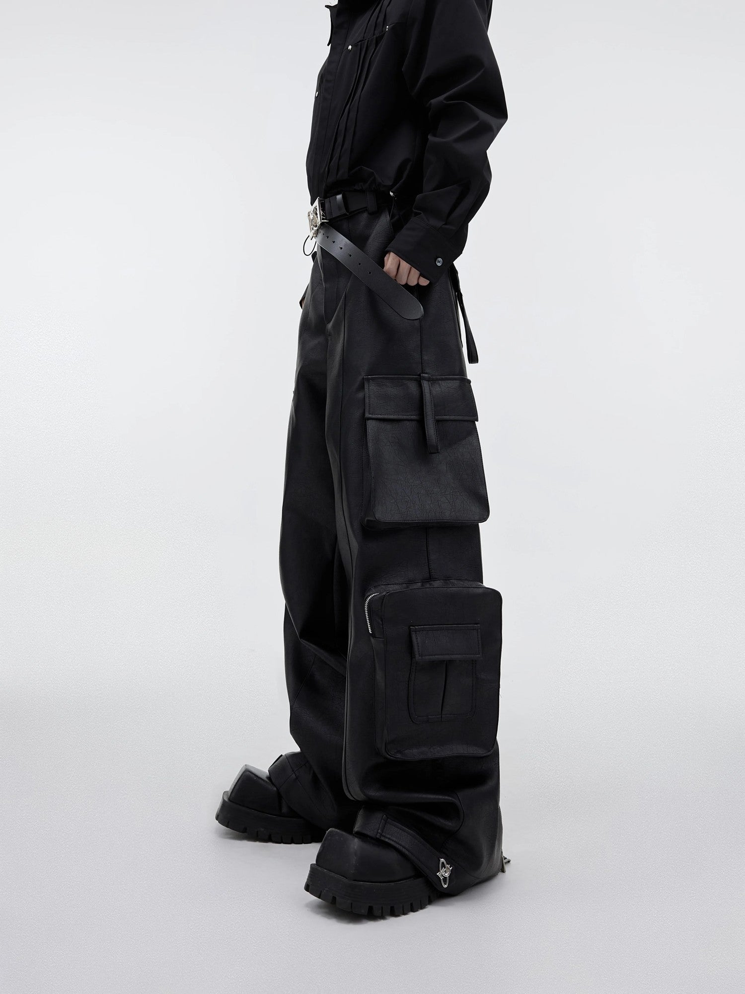 Front view of black wide-leg PU leather cargo pants with 3D pockets